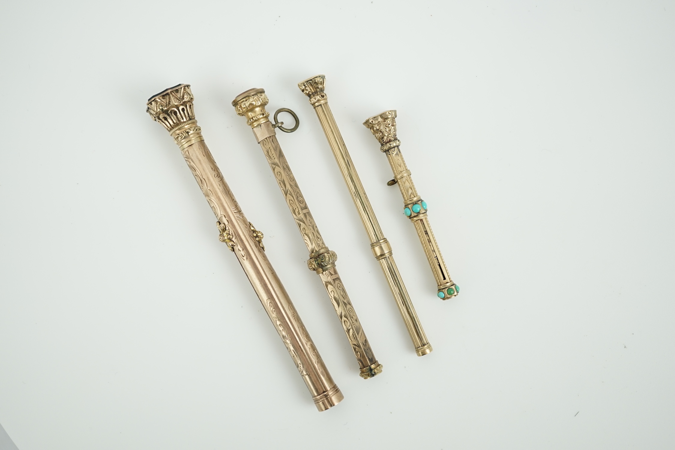 Four assorted late 19th/early 20th century yellow metal overlaid and gem set propelling pencils, largest set with bloodstone with pen and pencil, 97mm.